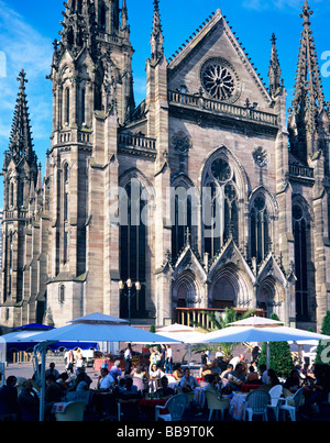 Patroni seduto fuori al caffè terrazza E ST-ETIENNE CHIESA MULHOUSE ALSACE FRANCIA Foto Stock