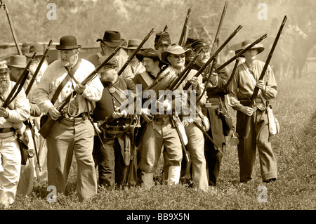 I soldati confederati sul campo di battaglia con moschetti in tonalità seppia durante una guerra civile rievocazione. Foto Stock