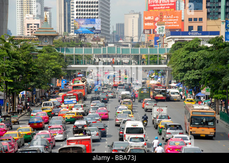 Grande città, ingorghi di traffico, auto e ciclomotori, nella parte anteriore del coloratissimo skyline, Ratchadamri Road, Bangkok, Thailandia, Sud-est asiatico Foto Stock