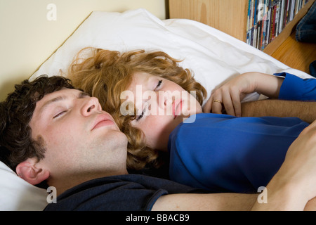 Una giovane coppia giacendo in letto insieme Foto Stock