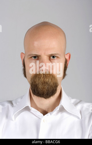 Un uomo con i baffi lunghi capelli che copre la sua bocca Foto Stock