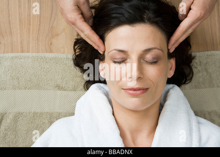 Una donna con un massaggio della testa Foto Stock