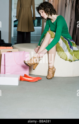 Una donna cercando su scarpe in un negozio Foto Stock
