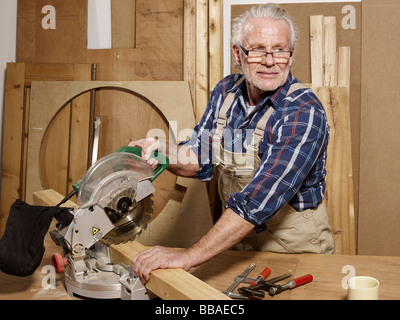 Un uomo di segatura di legno in un workshop Foto Stock