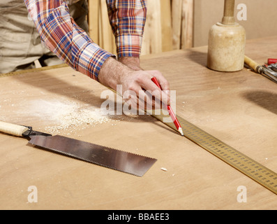 Dettaglio della marcatura uomo pezzo di legname utilizzando una matita e il righello Foto Stock