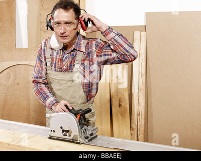 Un uomo utilizzando una sega circolare Foto Stock