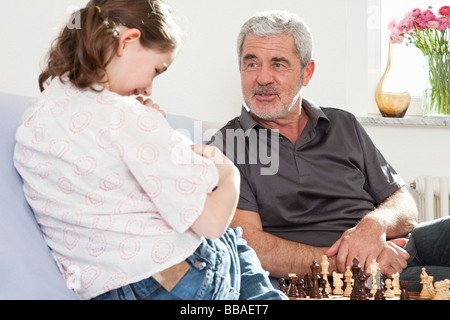 Un nonno e suo nipote giocando a scacchi Foto Stock