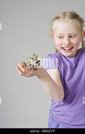 Una ragazza con una rana principe Foto Stock