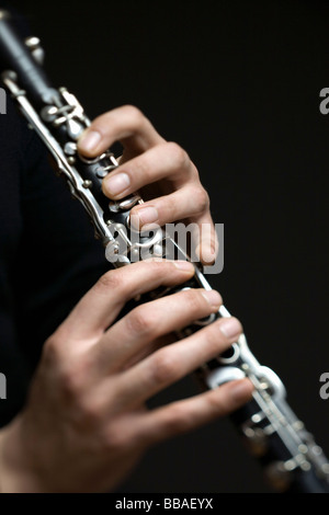 Le mani umane giocando un clarinetto Foto Stock