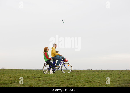 Una famiglia giovane in sella a una moto insieme Foto Stock