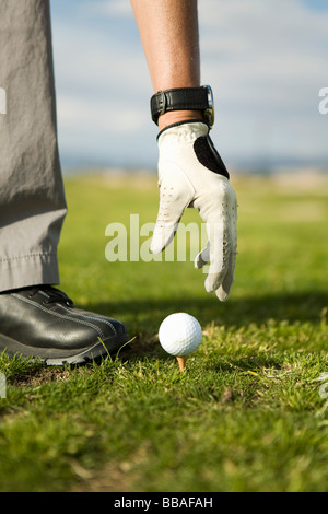 Dettaglio di una donna mettendo una pallina da golf su un raccordo a T Foto Stock