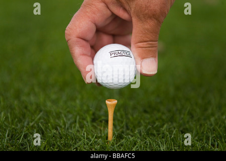 Dettaglio di un golfista ponendo una pallina da golf su un raccordo a T Foto Stock