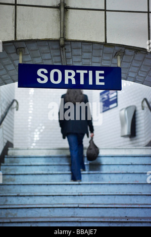 Donna di arrampicata stazione ferroviaria scale Foto Stock