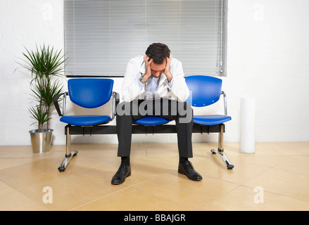 Medico con la testa tra le mani Foto Stock