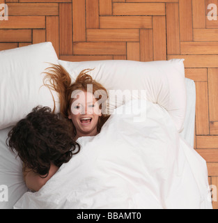 Giovane ingannare intorno a letto Foto Stock