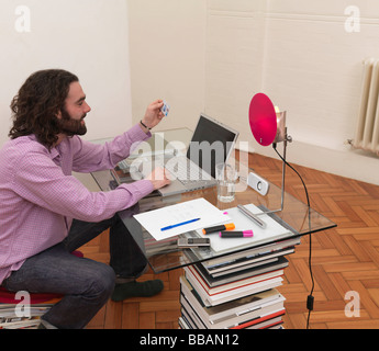 Uomo con notebook, azienda carta di credito Foto Stock