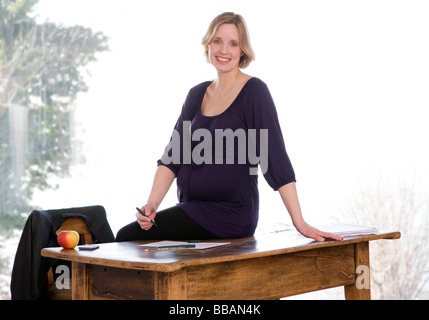 Donna incinta che lavorano in ufficio in casa Foto Stock