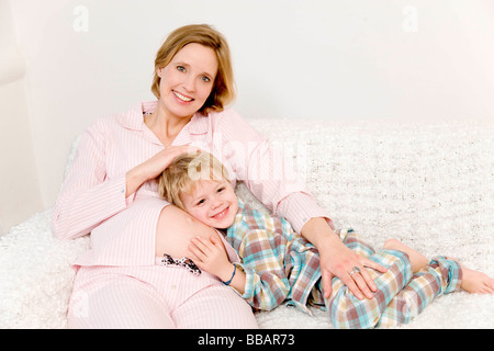 Donna incinta e ragazzo ridendo Foto Stock