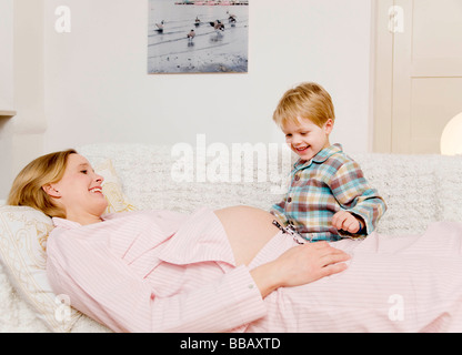 Donna incinta e ragazzo ridendo Foto Stock