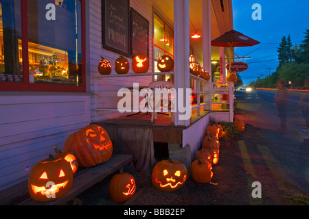 Vashon Island WA grande collezione di Jack O lanterne al tramonto sulla notte di Halloween sotto il portico del Roasterie cafe Foto Stock