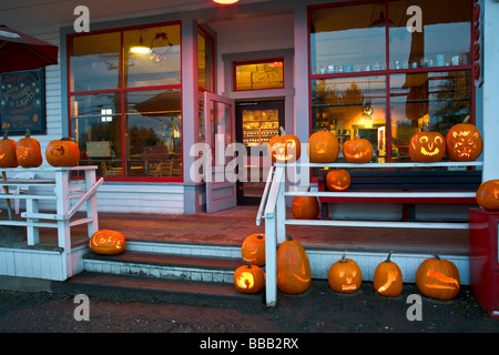 Vashon Island WA grande collezione di Jack O lanterne al tramonto sulla notte di Halloween sotto il portico del Roasterie cafe Foto Stock