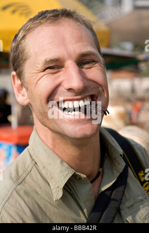 Tourist mangiare fritte Tarantulas al mercato Skuom sulla strada tra Phnom Penh e Siem Reap Foto Stock