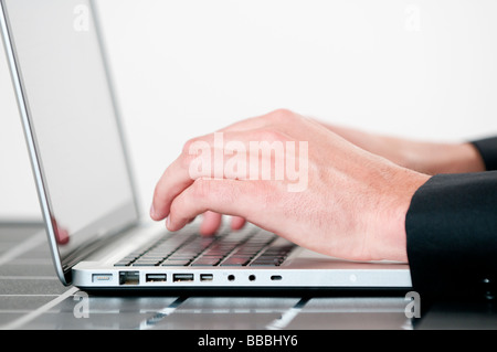 Primo piano di un imprenditore s mani digitando su una tastiera portatile Foto Stock