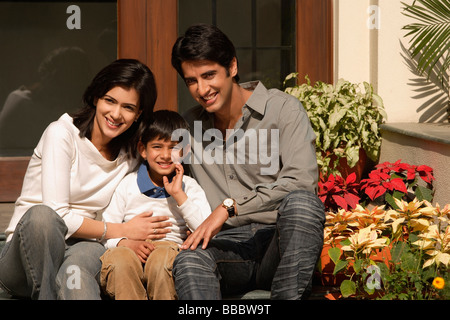 Padre, madre, figlio sorriso per fotocamera su porte anteriori Foto Stock