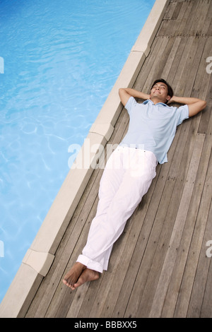 Reclinazione uomo in piscina Foto Stock