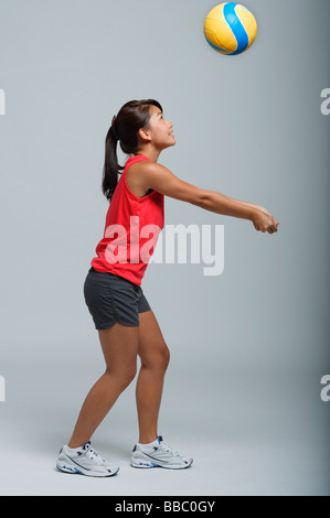 Giovane donna che gioca con la pallavolo Foto Stock