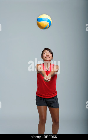 Giovane donna che gioca con la pallavolo Foto Stock