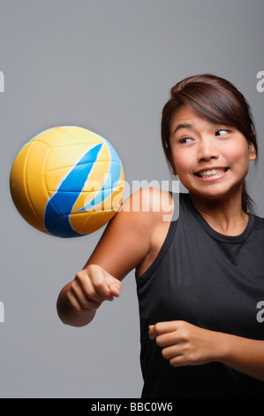 Giovane donna che gioca con la pallavolo Foto Stock