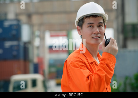 Operaio edile parlando su walkie-talkie Foto Stock