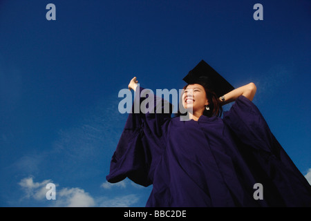 Una giovane donna vestita nel suo abito di graduazione Foto Stock