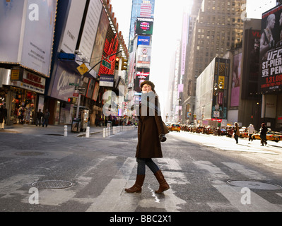 Donna di strada di attraversamento in Times Square Foto Stock