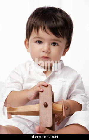 Indian baby boy holding aeroplano giocattolo Foto Stock