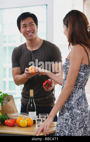 Giovane a casa, donna uomo passando un frutto Foto Stock