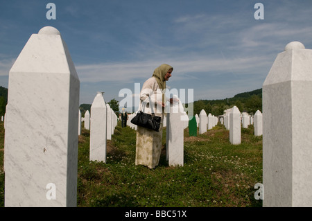 Una donna musulmana bosniaca cammina tra tombe dei suoi parenti, vittime del genocidio Srebrenica, nel cimitero di Potocari, vicino a Srebrenica, in Bosnia Foto Stock