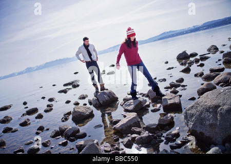 Giovane camminando sulle rocce vicino al lago Foto Stock