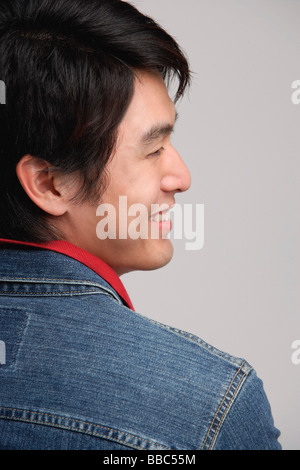 Uomo sorridente, al di sopra della spalla Foto Stock