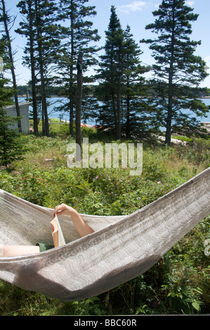 Donna relax sulle amache e la lettura Foto Stock