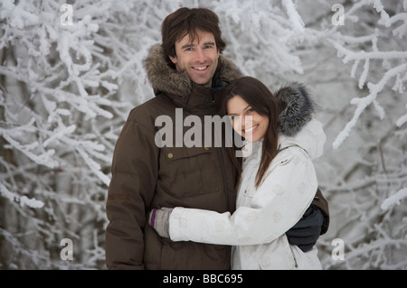 Coppia dalla coperta di neve alberi. Foto Stock