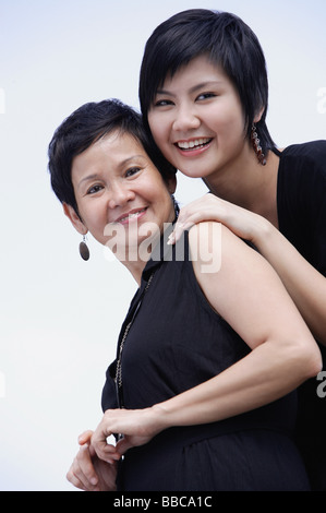 Madre e figlia adulta sorridente, guardando la fotocamera Foto Stock