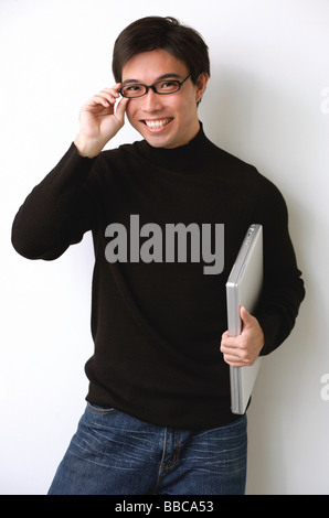 Uomo con notebook, occhiali di regolazione Foto Stock