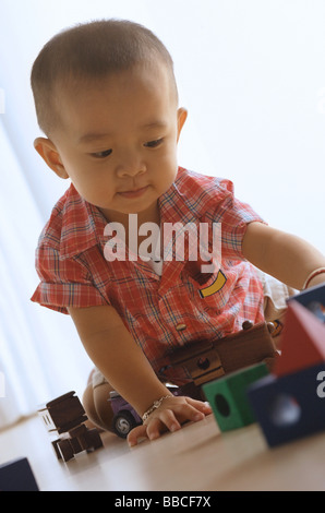 Ragazzo sul pavimento, giocando con il trenino Foto Stock