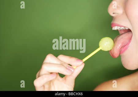Donna leccare lecca-lecca, vista laterale Foto Stock