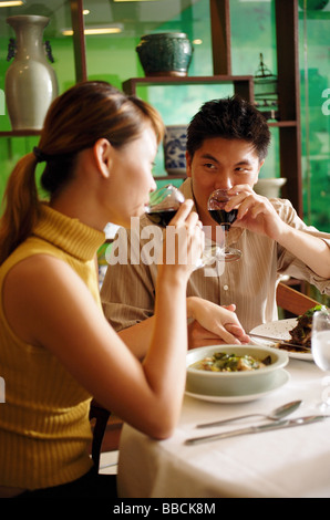 Matura in un ristorante Cinese, bere vino Foto Stock
