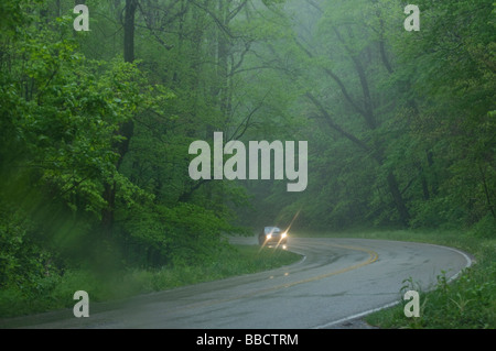 Auto con fari anteriori sulla guida tramite il sensore di pioggia Foto Stock