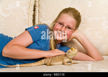 Ritratto giovane ragazza 9-11 anni sorrisi a telecamera petting drago barbuto, copia spazio, intaglio, caucasian,close up, primo piano Foto Stock