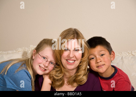 Mamma single con figlia 9-11 anni e ha adottato multi etnico ispanico foster figlio 6-7. Sfondo bianco degli STATI UNITI STATI UNITI STATI UNITI D'AMERICA SIGNOR © Myrleen Pearson Foto Stock